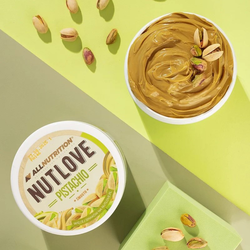 Allnutrition Nutlove Pistachio Smooth is a creamy pistachio spread, shown in a 500g tub with pistachio imagery on the label and a smooth, greenish-brown spread inside the open container.